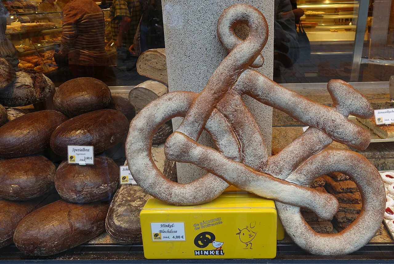 Bread loaves and a bicycle-shaped pastry in the window of Bäckerei Hinkel, Düsseldorf.