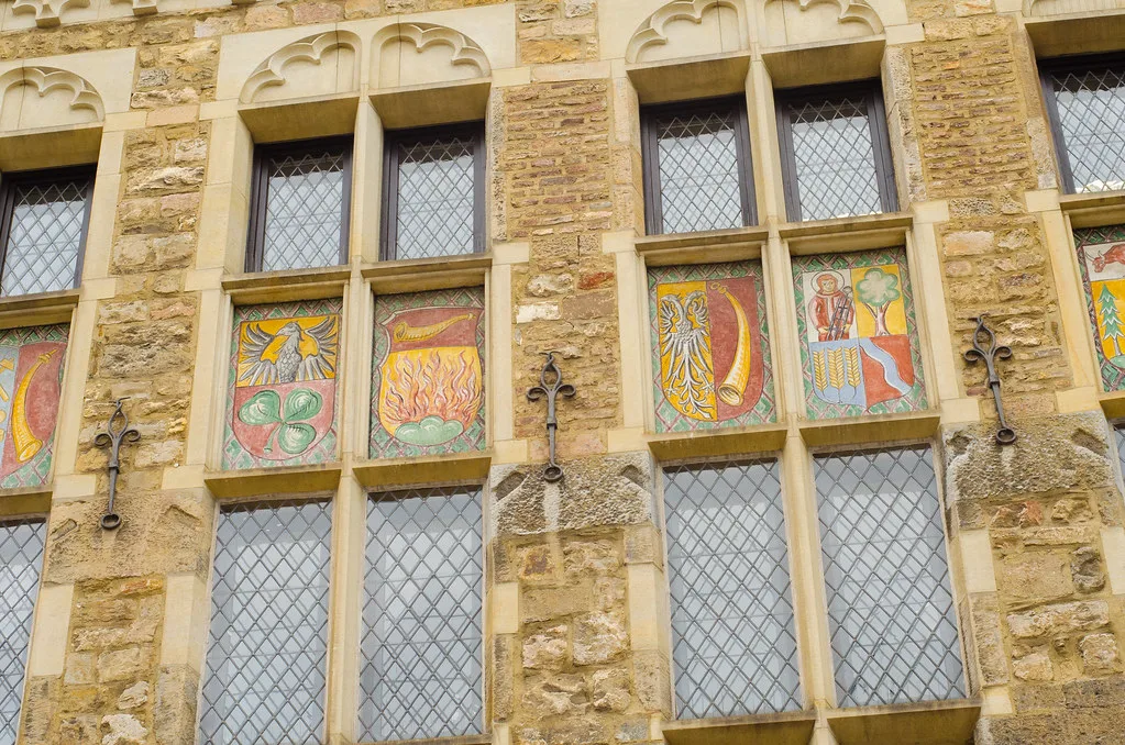 Painted shields on a historic building on the Marktplatz, Aachen.