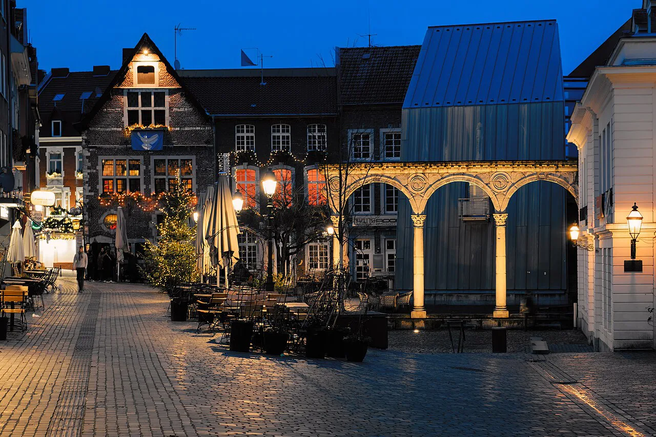 Outdoor tables on the Hof square in Aachen's old town in the evening.