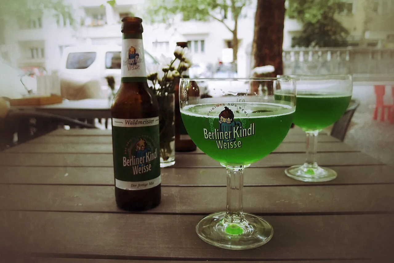 Green Berliner Weisse with woodruff syrup on a table in Berlin.