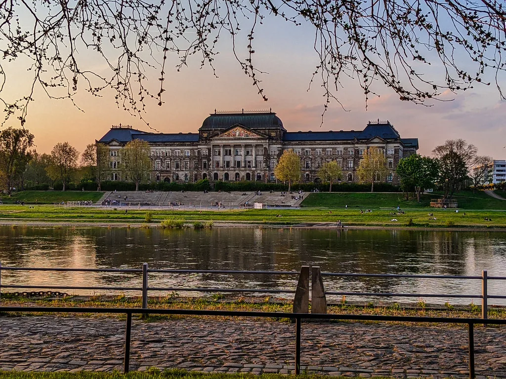 Dresden's Elbe riverbank and old town buildings at dusk.
