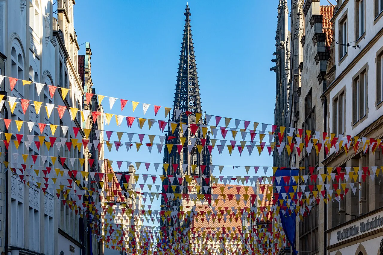 The Prinzipalmarkt decked with bunting below the spire of St. Lamberti Church, Münster.