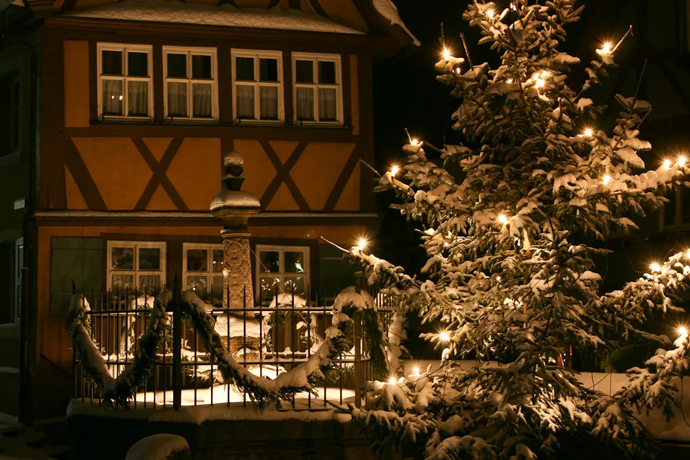 A half-timbered house and Christmas tree lit up in December, Rothenburg ob der Tauber.