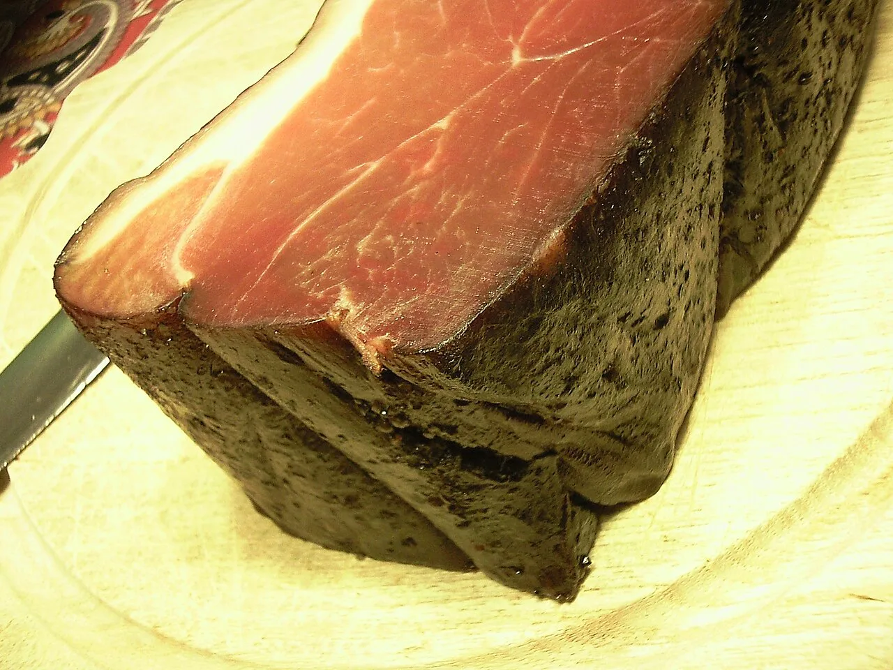 A block of smoked Black Forest ham with its dark crust.