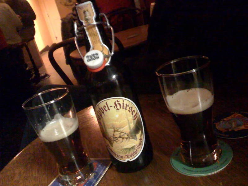 A bottle of Doppelbock poured into two glasses.