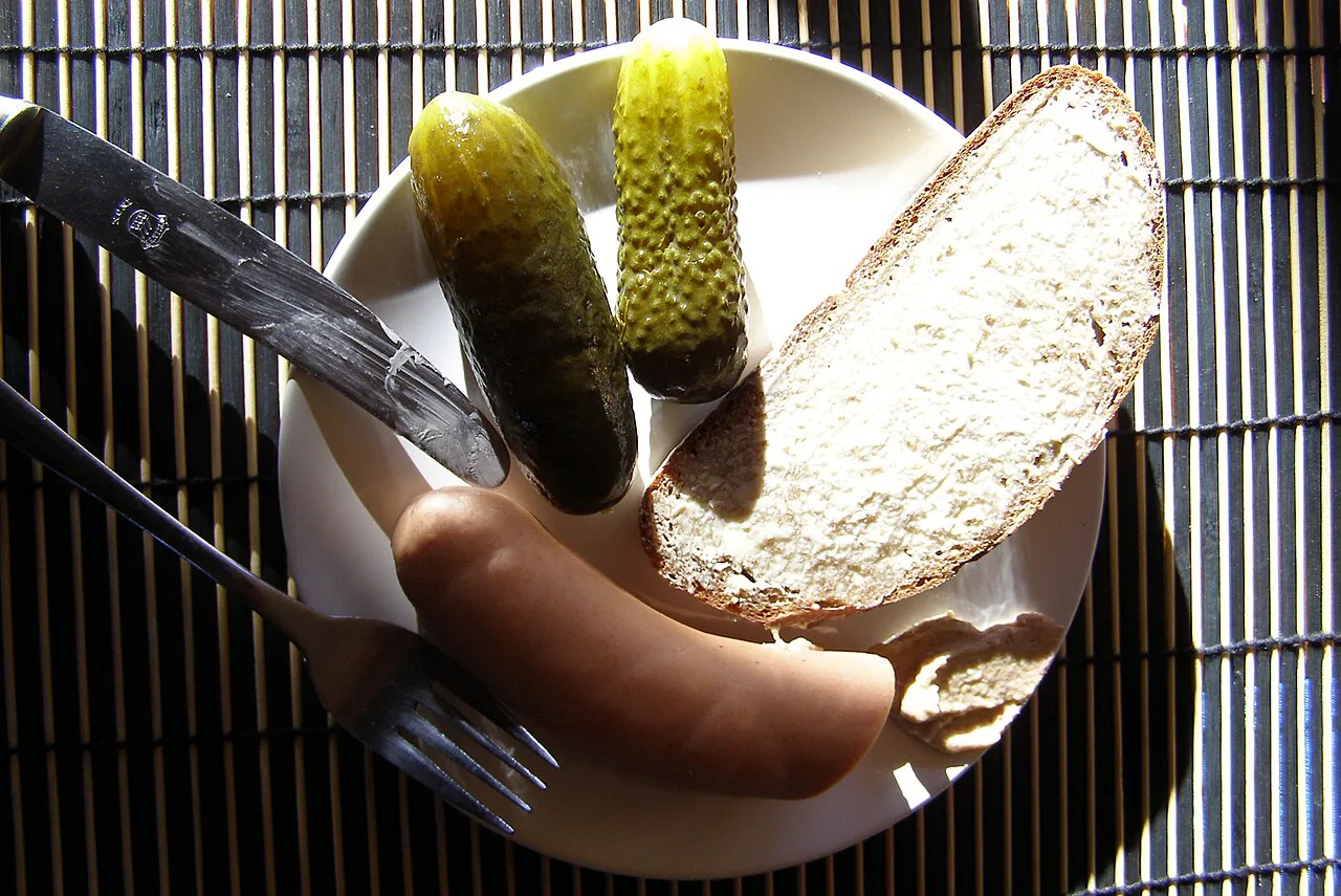 Bockwurst with mustard, buttered bread and pickles.
