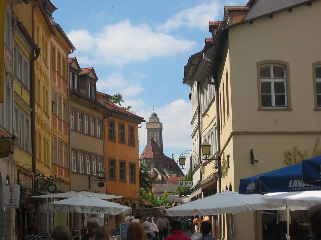 A narrow old-town lane with café umbrellas, Bamberg.