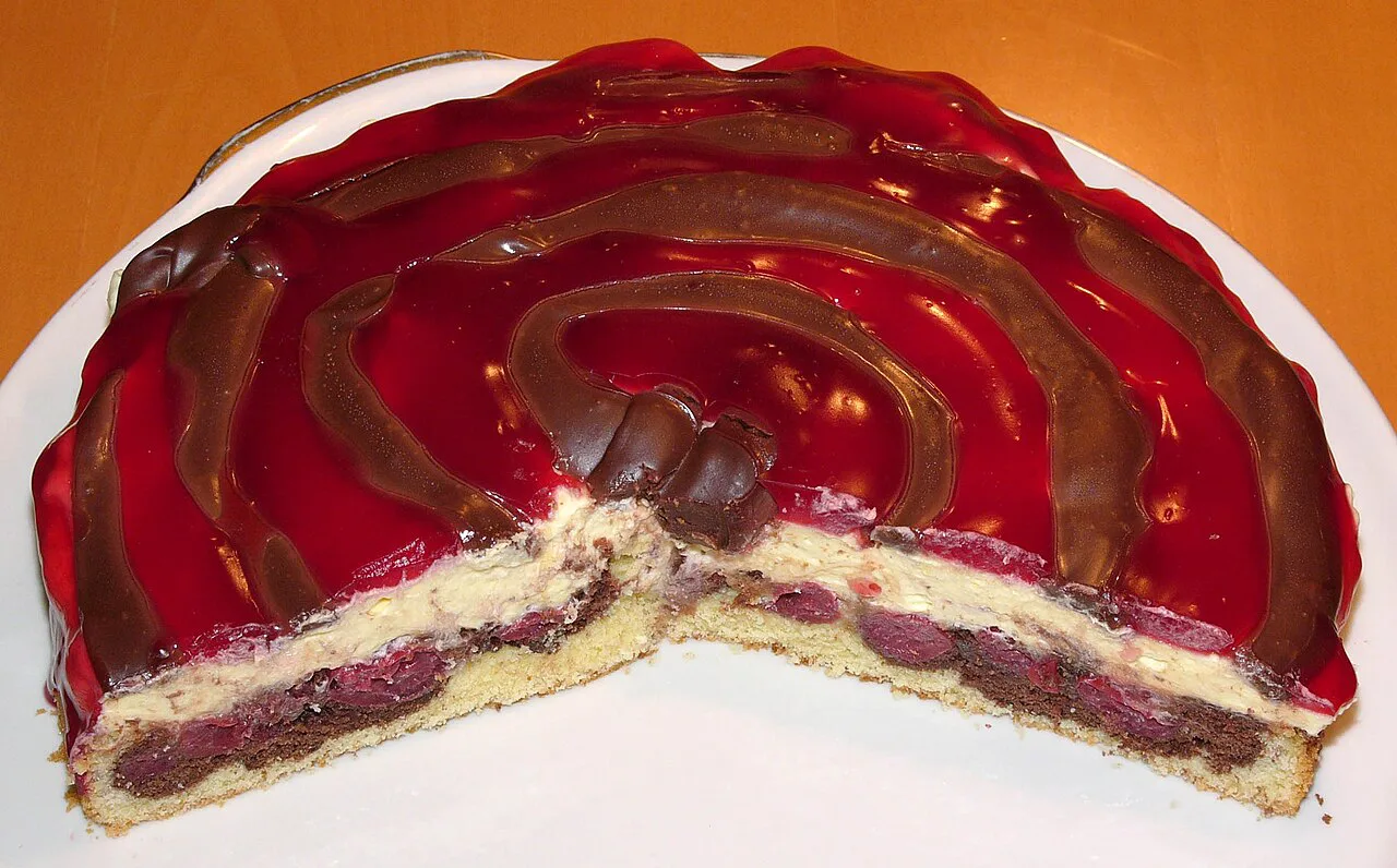 A round Donauwelle cake with sour cherries, vanilla cream and chocolate glaze.