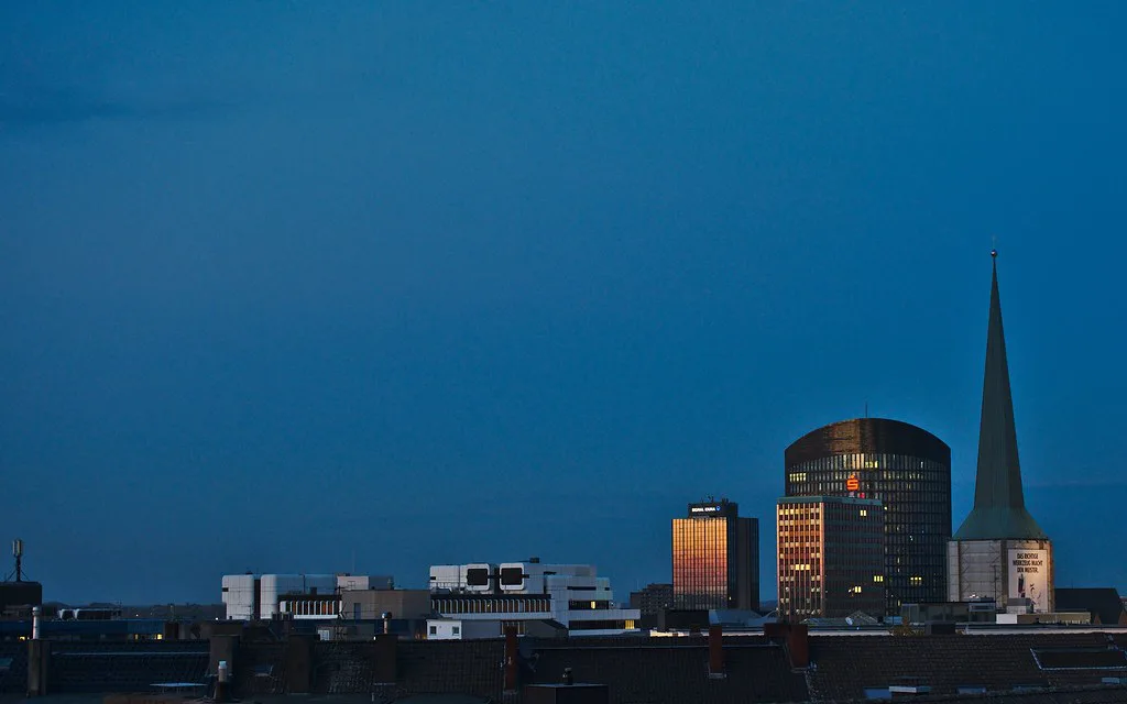 The Petrikirche spire and the Dortmunder U on the Dortmund skyline at dusk.