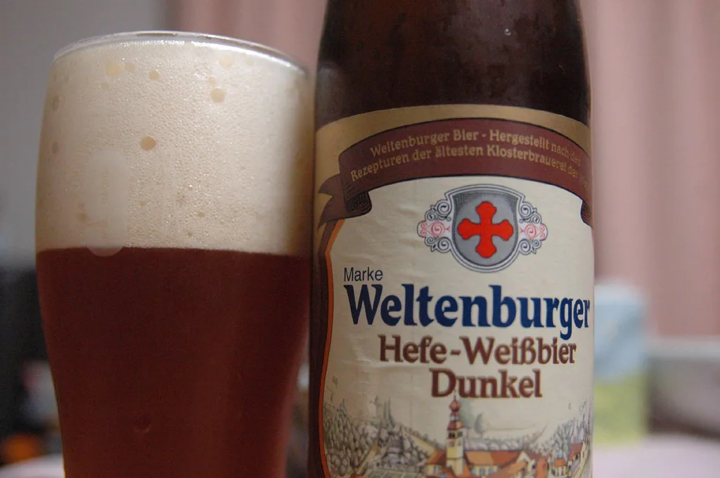 Weltenburger dark wheat beer poured beside its bottle.