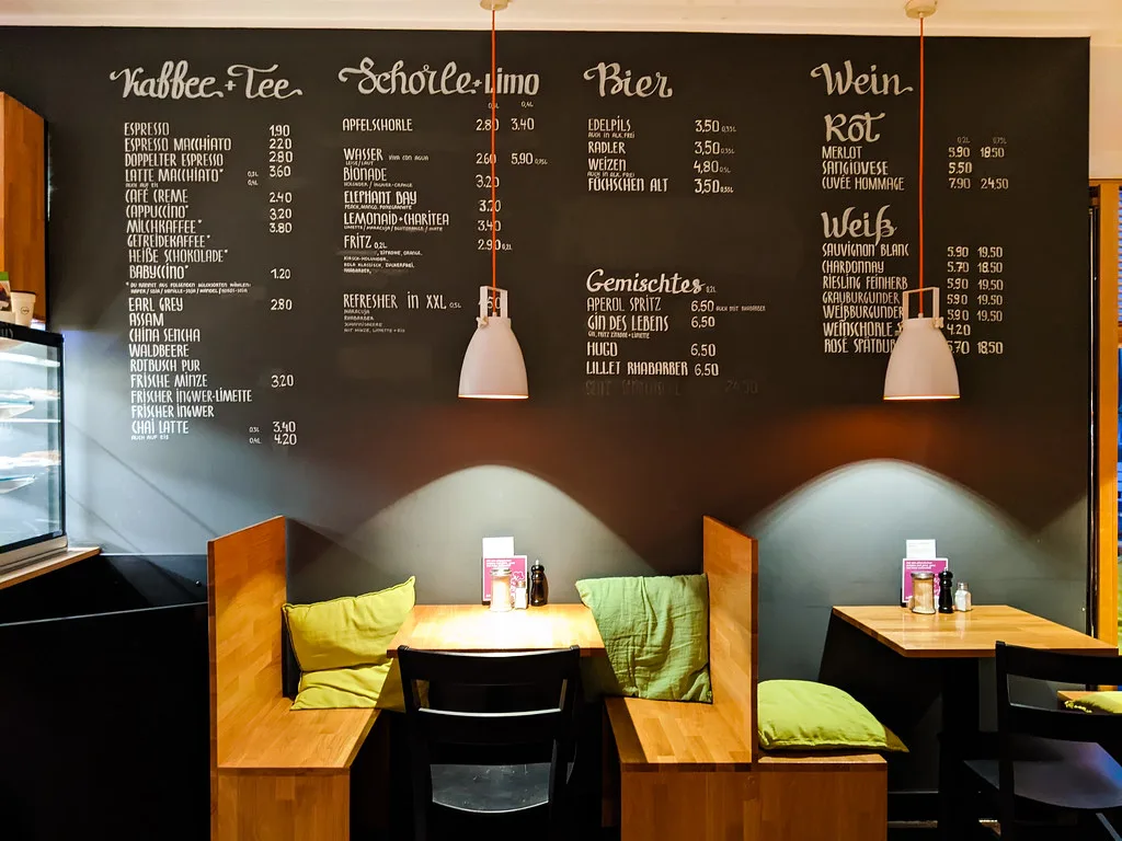 Booth seating and a chalkboard drinks menu at the Sattgrün vegan restaurant, Düsseldorf.