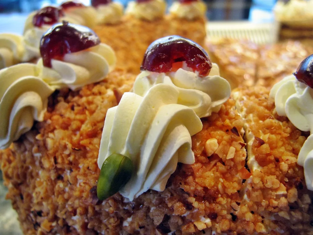 Close-up of Frankfurter Kranz with buttercream rosettes, cherries and nut brittle.