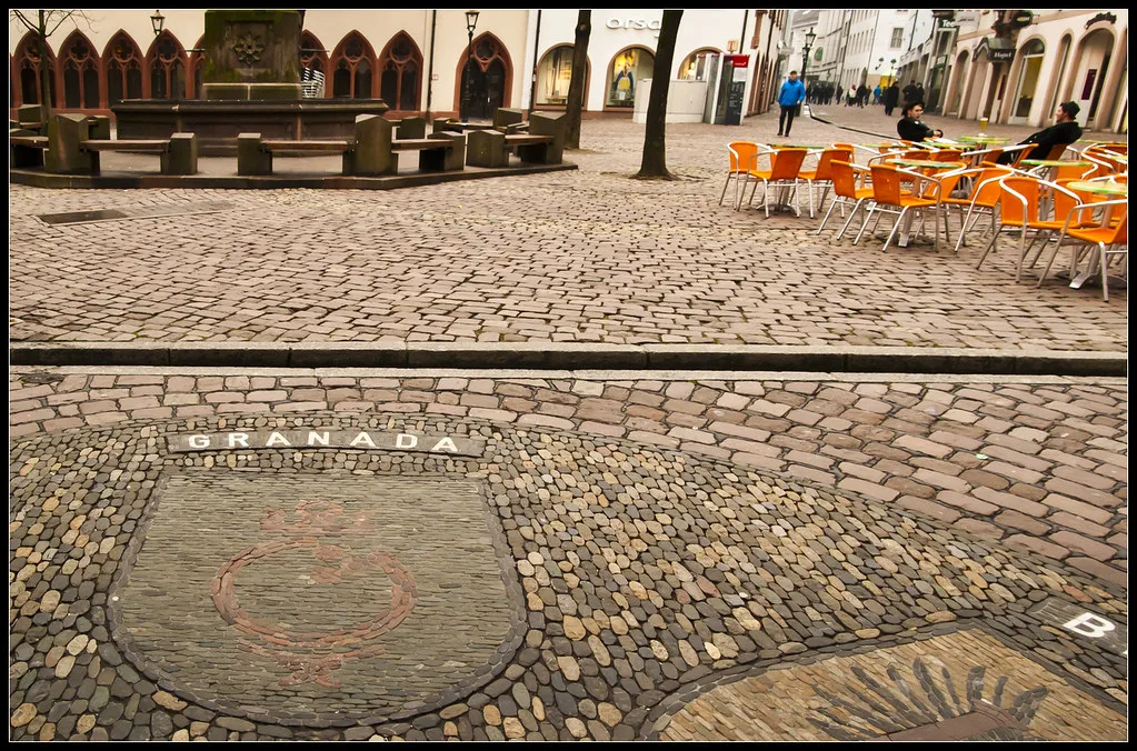 Café chairs on a square in Freiburg's old town.
