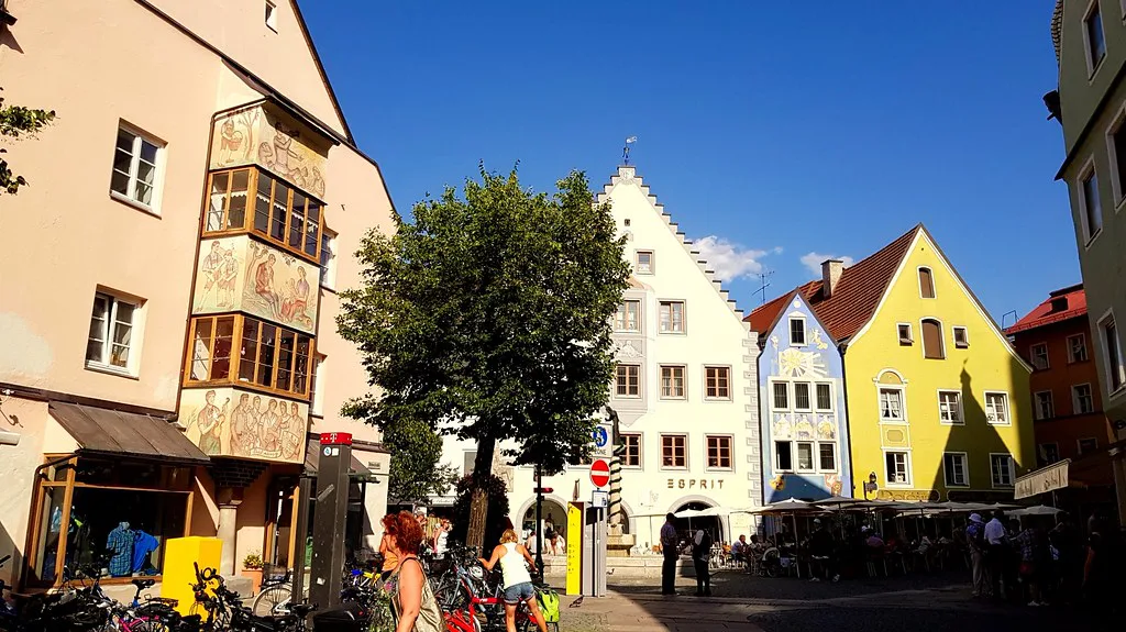 Colorful houses and café tables on an old-town street in Füssen.