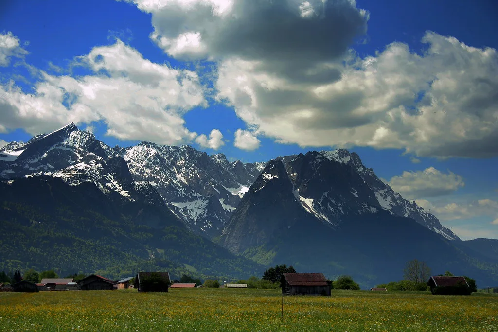 Alpine peaks above meadows and hay huts near Garmisch-Partenkirchen.