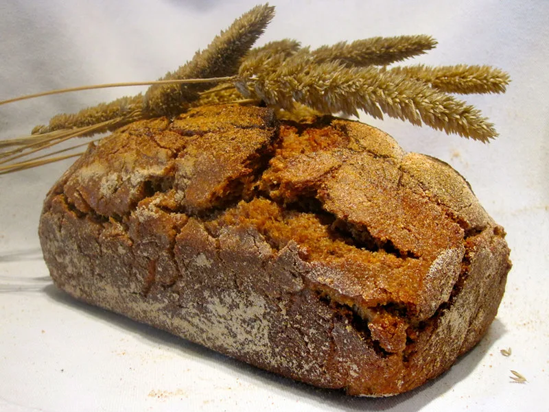 A round sourdough rye loaf with ears of grain.