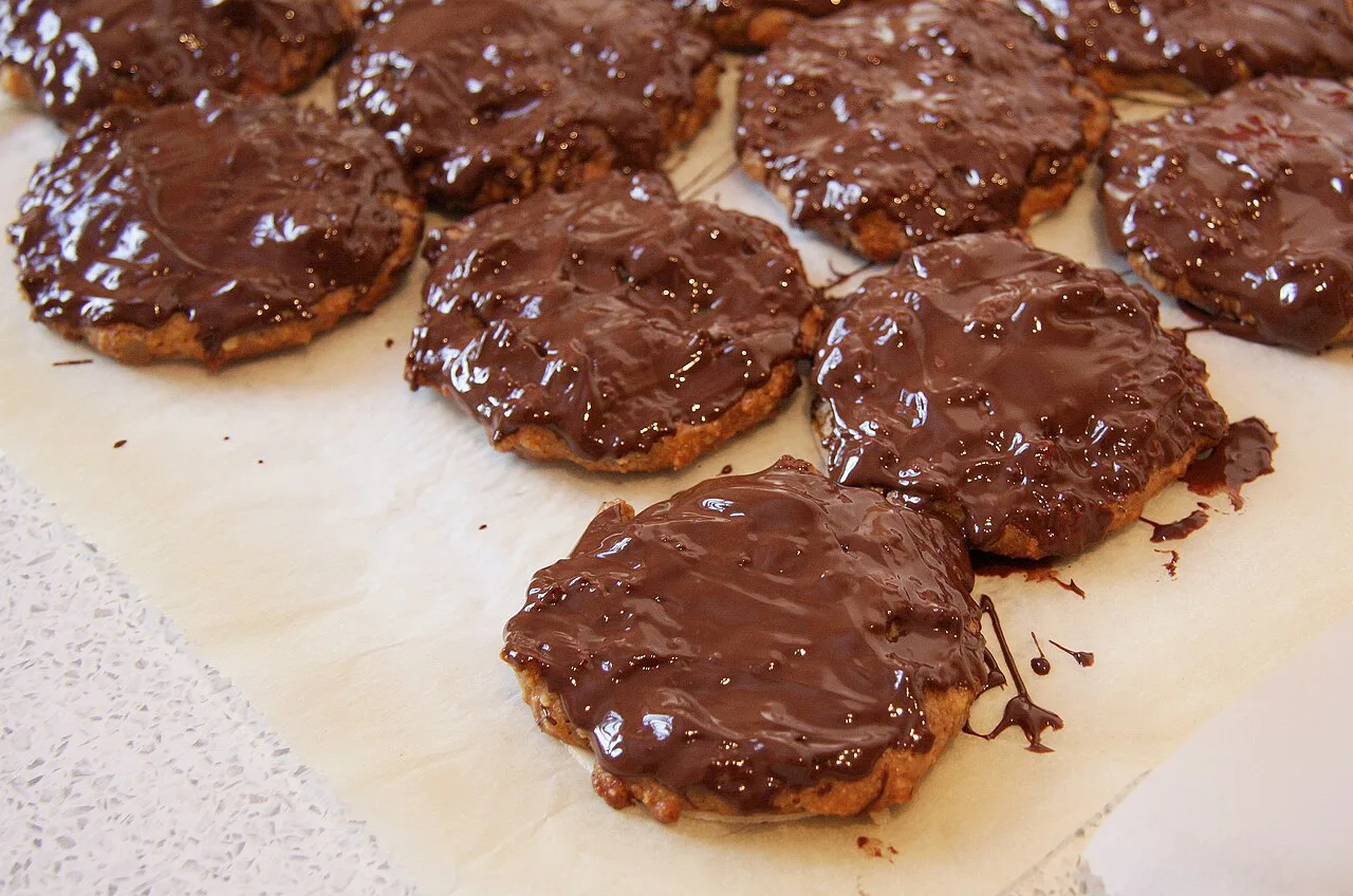 Homemade chocolate-glazed Elisen Lebkuchen cooling on baking paper.
