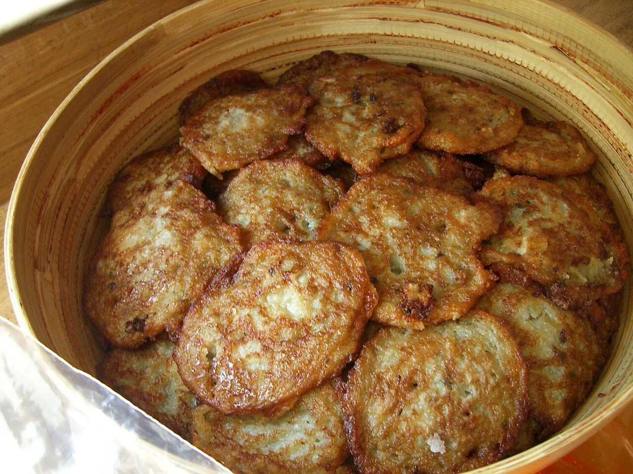 A tin of freshly fried potato pancakes.