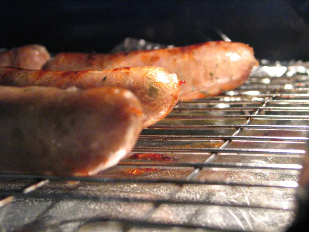Sausages cooking on a grill.
