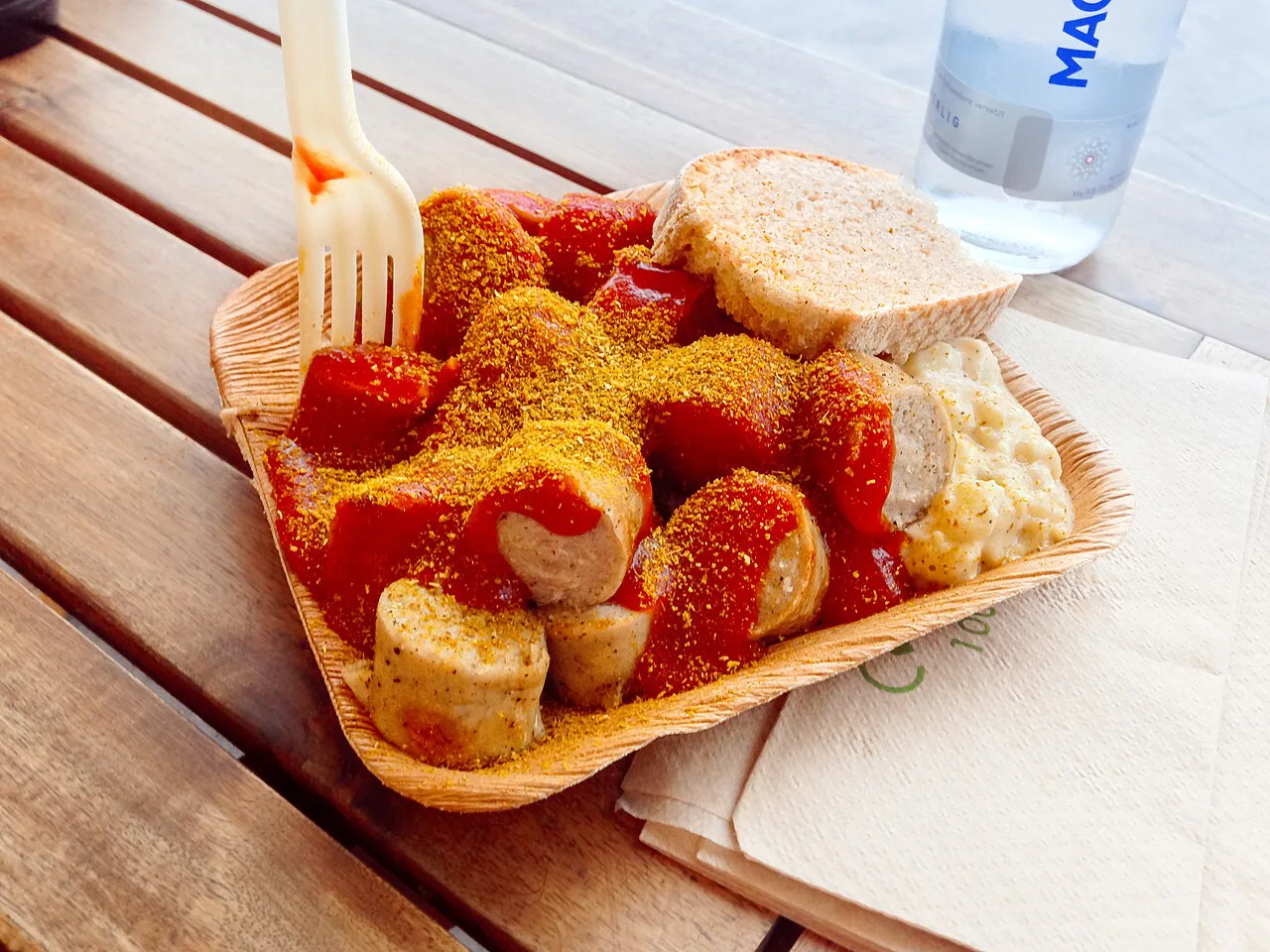 Currywurst with bread and potato salad from a snack stand.