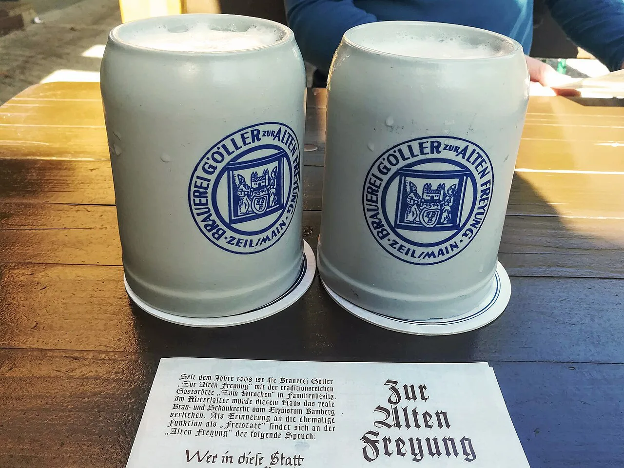 Stoneware mugs of Göller Helles in the brewery's beer garden in Zeil am Main.