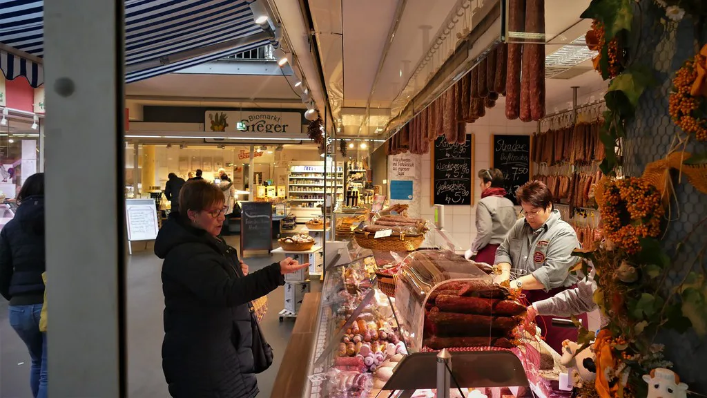 Sausages hanging at a deli counter in a covered market hall.