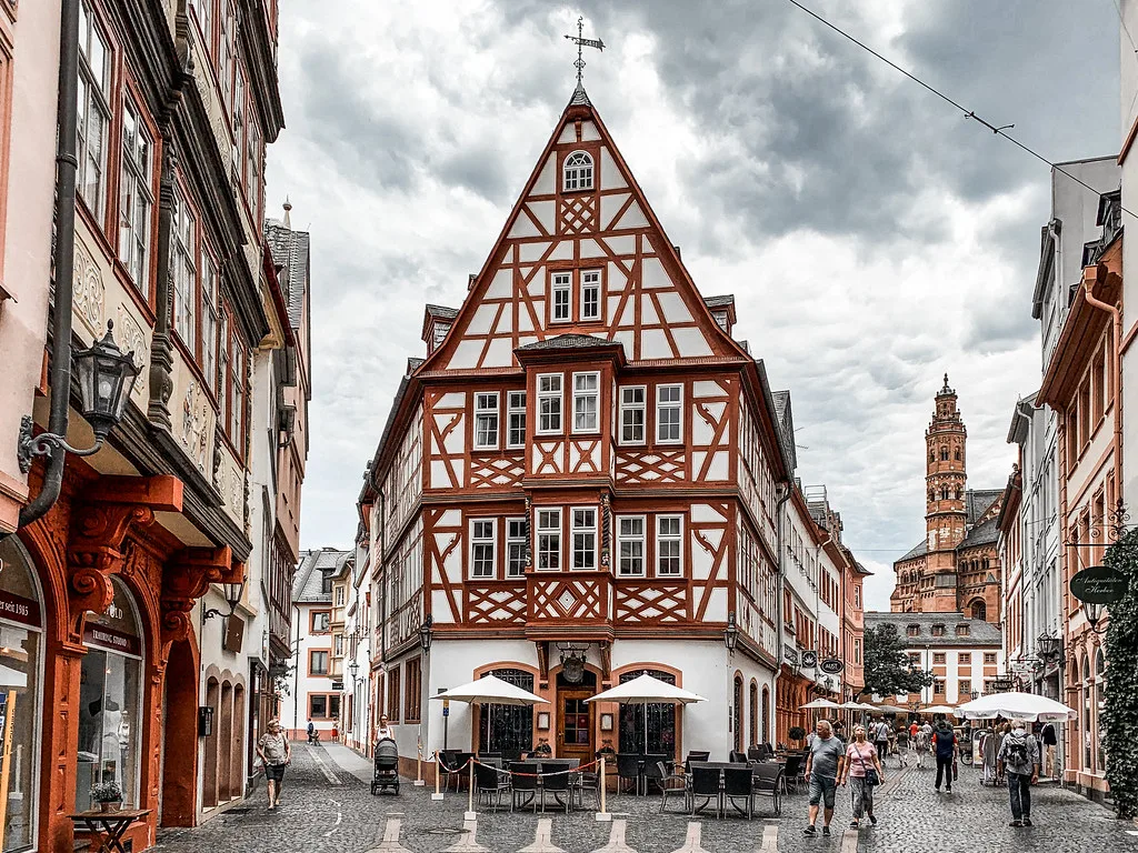 Half-timbered houses and outdoor tables near the Weinhaus Zum Spiegel in Mainz old town.
