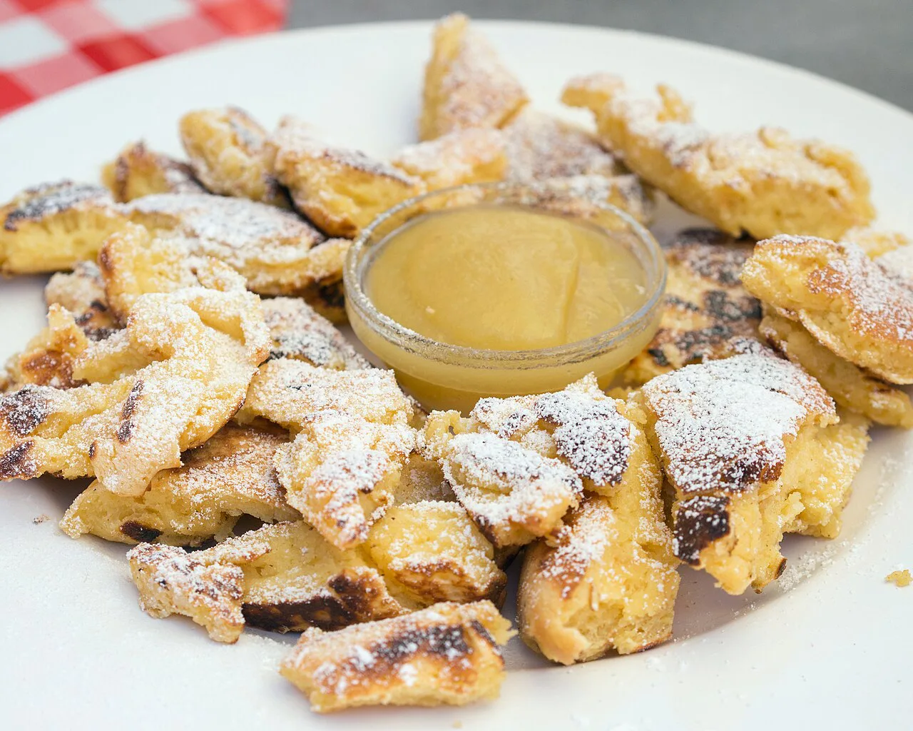 Kaiserschmarrn dusted with powdered sugar and served with apple sauce.