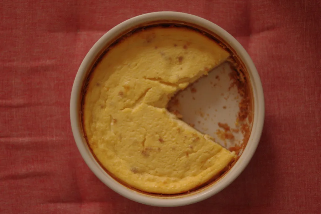 A baked cheesecake with one slice cut out.