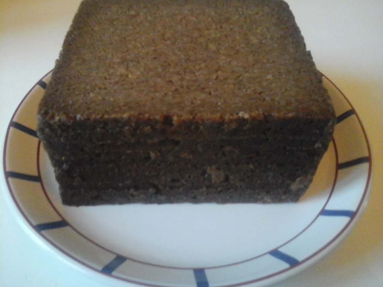 A block of German pumpernickel on a plate.
