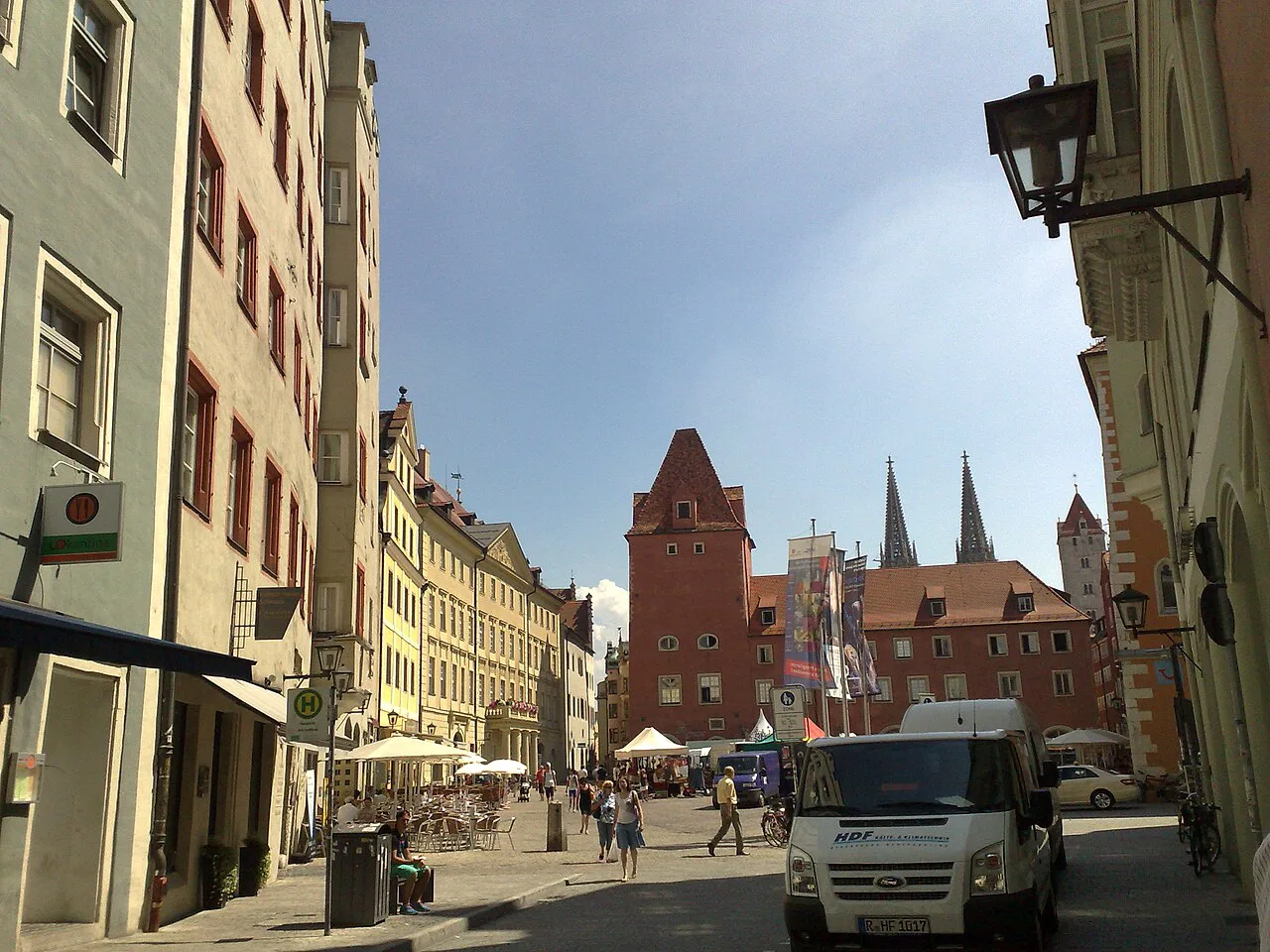 A street in Regensburg's old town leading to a medieval tower.