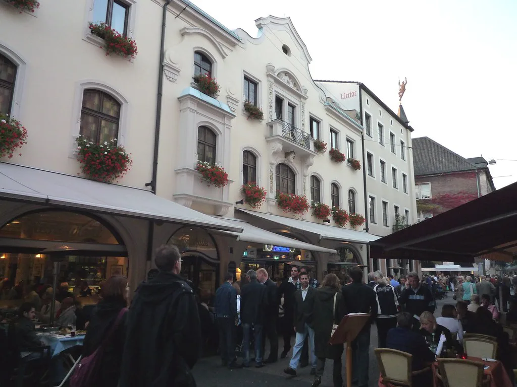 Restaurant terraces on an old-town street at dusk, Düsseldorf.