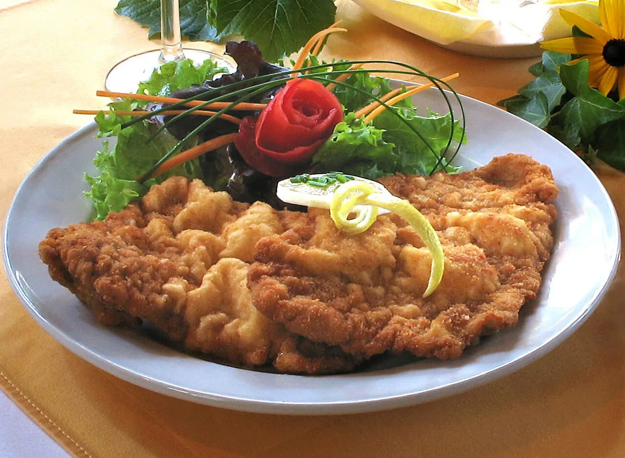 Wiener schnitzel garnished with lemon and salad.