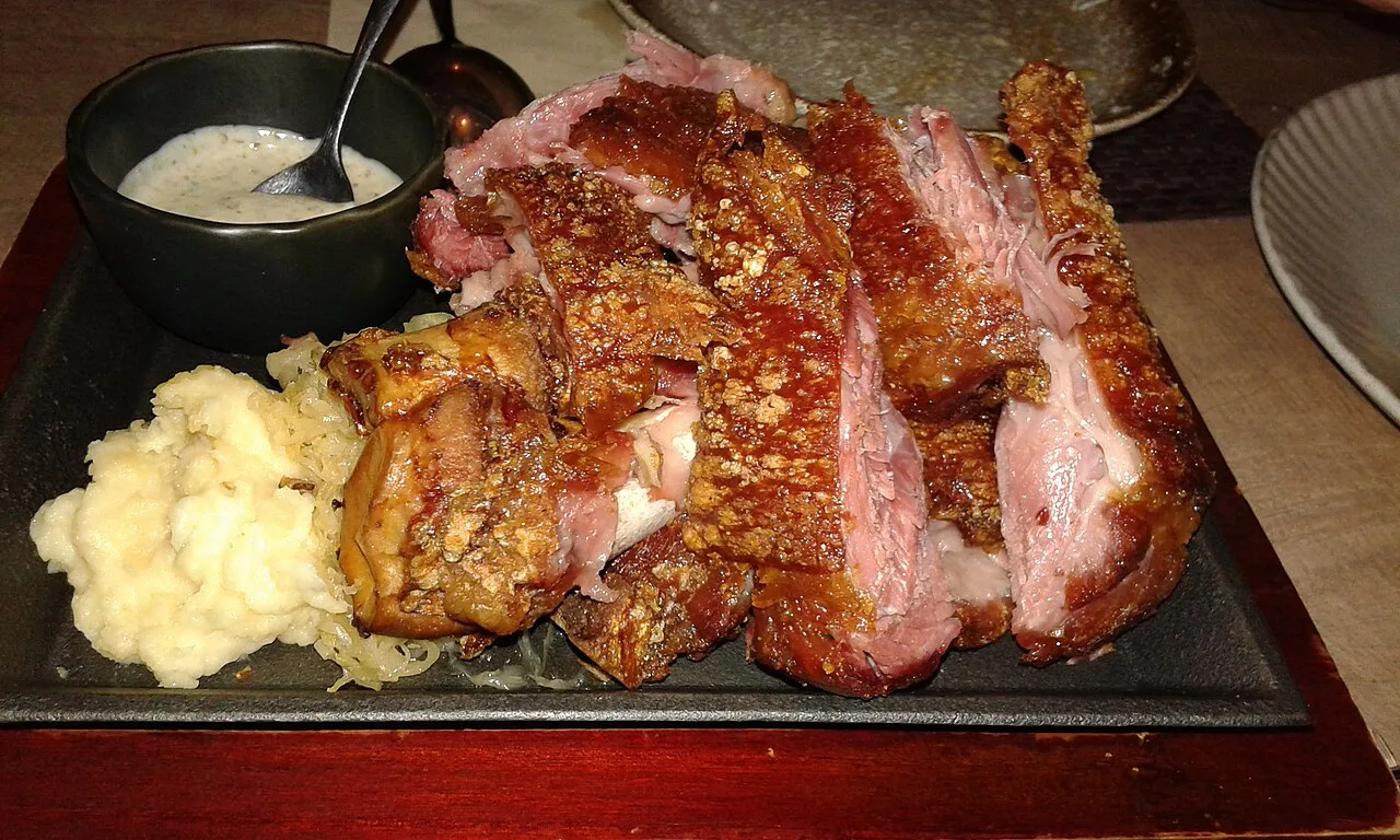 Carved Schweinshaxe with crisp crackling and mashed potatoes.