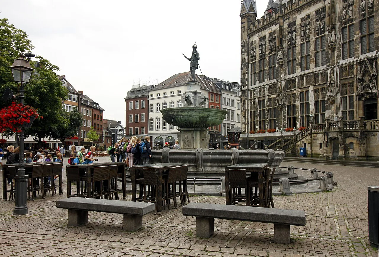Outdoor tables beside the Karlsbrunnen fountain on Marktplatz, Aachen.