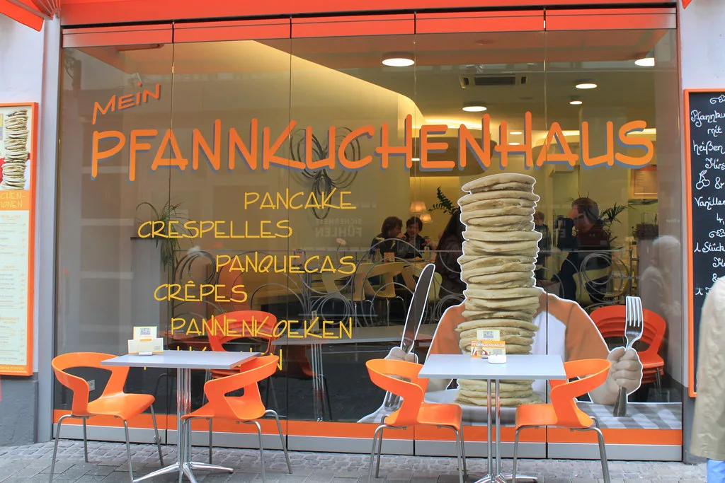 A pancake house storefront with outdoor tables, Trier.